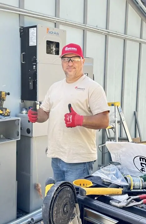 Alex from Menderix beside solar and battery equipment